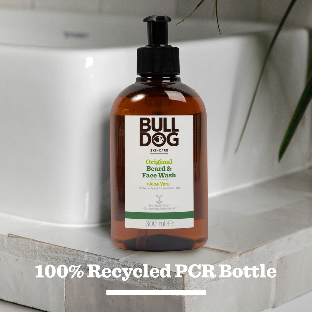 A 300 ml bottle of Original Beard & Face Wash rests on the bathroom counter, its label noting natural origin ingredients and a 100% recycled PCR bottle.