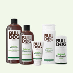The Premium Body Care Bundle stands upright in white and brown packaging with green accents, including shower gel, shampoo, hand cream, body lotion, and Natural Deodorant with aloe vera on a light background.