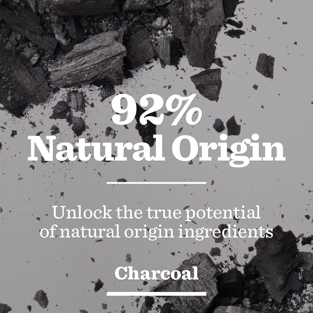 Charcoal pieces on a light background with text: 92% Natural Origin. Experience the power of natural ingredients with Oil Control Face Scrub for men.