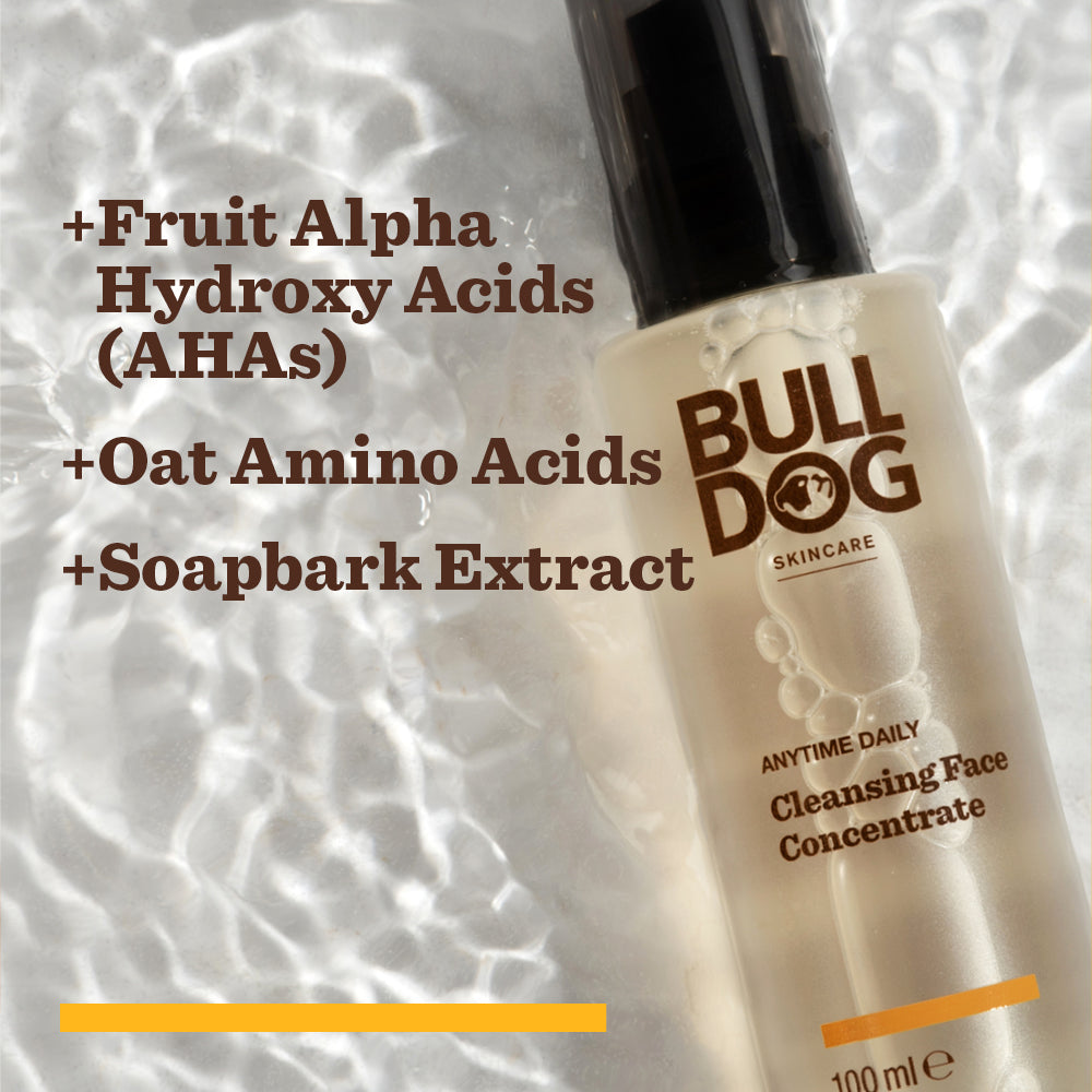A bottle of Anytime Daily Cleansing Face Concentrate sits on rippled water, highlighting its natural origin ingredients: Fruit Alpha Hydroxy Acids (AHAs), Oat Amino Acids, and Soapbark Extract.